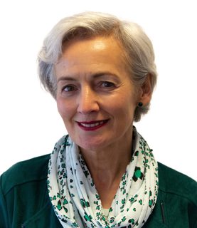 Angiolina Foster headshot. She smiles and wears a white scarf with green patern and green jumper.