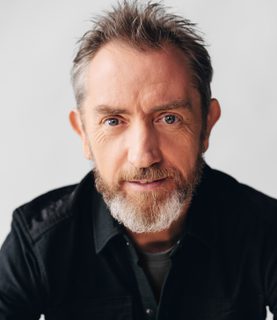 David Brophy smiles at the camera against a white background.