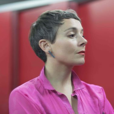Soprano Anna Dennis gazes towards the right of the image, her head held high, a serious look on her face.