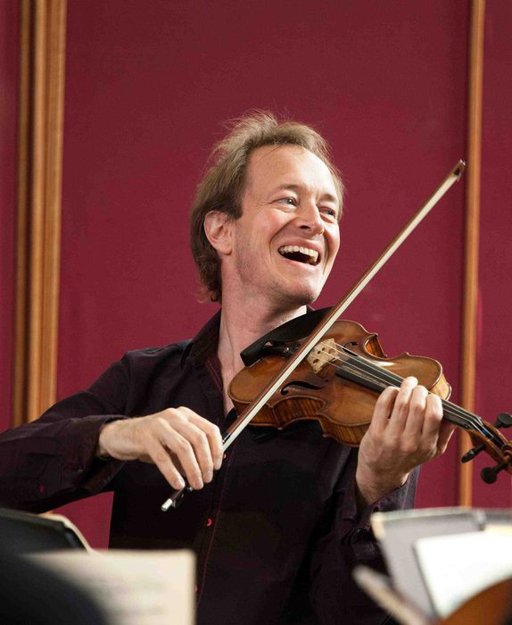 Violinist Anthony Marwood plays the violin, laughing as he looks to his left.