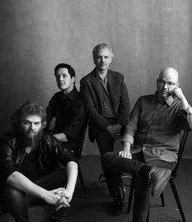 Monochrome image of Brooklyn Rider string quartet against a grey background.