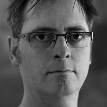 Black and white headshot of Chris Ekers.