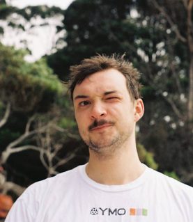 DJ Jamie Pettinger winks with his left eye, looking directly at the camera.