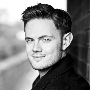 Black and white image of Nick Pritchard smiling into the camera.