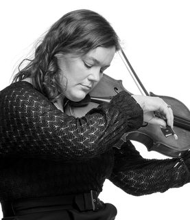 Fran plays the viola. She wears a black knitted-style top.