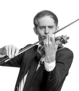 Afonso plays the violin. He wears a black suit and tie.