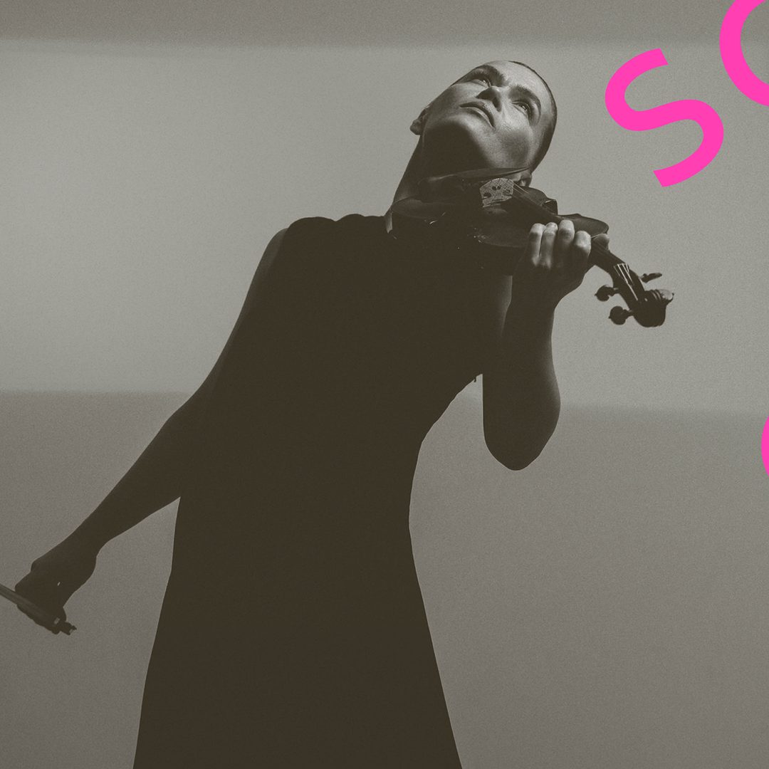 Mari Samuelson leans back and plays the vilin she wears a long black dress.