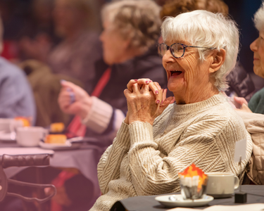 An audience member of the Tea Dance concert smiles with delight.