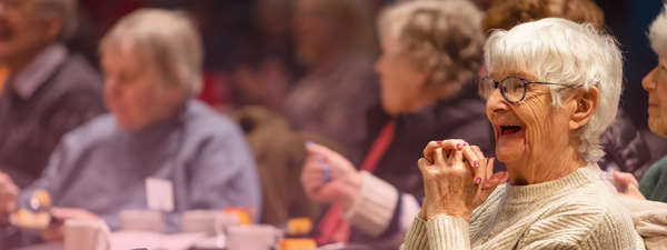 An audience member of the Tea Dance concert smiles with delight.