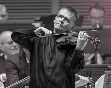 Pekka plays the violin with a smile.