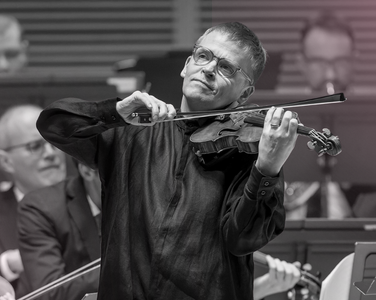 Pekka plays the violin with a smile.