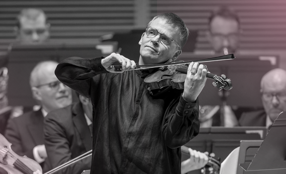 Pekka plays the violin with a smile.