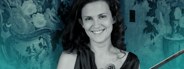 Lorenza Borrani smiles at the camera, holding her violin