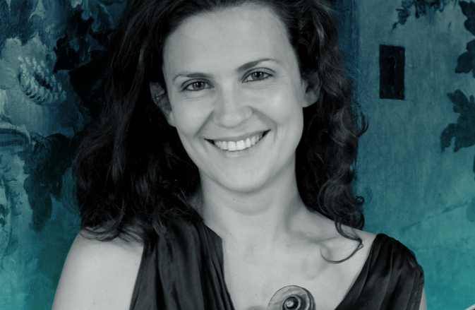 Lorenza Borrani smiles at the camera, holding her violin