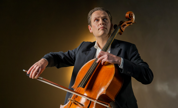 Eric plays the cello. He wears a black suit.