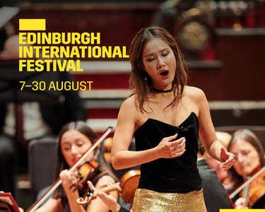 An opera singer sings with the SCO behind.