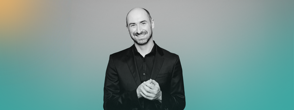 Peter Whelan wears a black shirt and smiles.