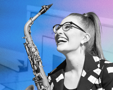 Jess Gillam smiles up holding her saxophone.