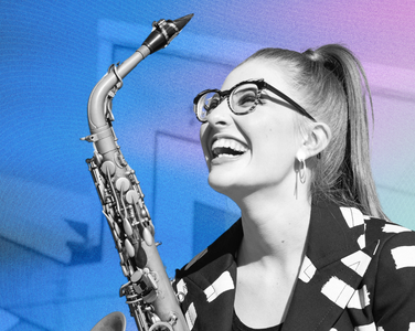 Jess Gillam smiles up holding her saxophone.