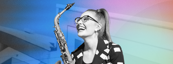 Jess Gillam smiles up holding her saxophone.