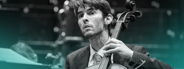 Philip Higham plays the cello. He wears a suit.