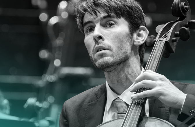 Philip Higham plays the cello. He wears a suit.