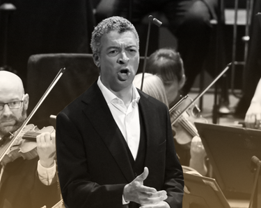 Roderick Williams sings at the Proms with the Orchestra playing behind.