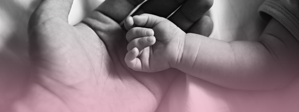 A baby'ss hand rests in an adults.