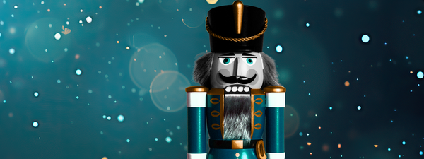 A blue nutcracker soldier is featured with a blue glistening backdrop.