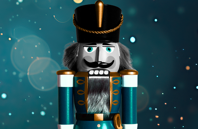 A blue nutcracker soldier is featured with a blue glistening backdrop.