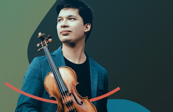 Violinist Aylen Pritchin stands holding his instrument, looking to the left with a smile on his face, against a dark background with bright red and green shapes.