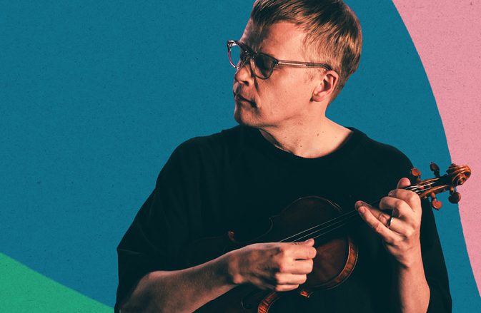 Pekka Kuusisto strumming his violin in front of a background with bright pink, green, and blue waves.