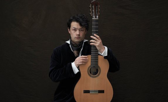 Sean Shibe holds a guitar