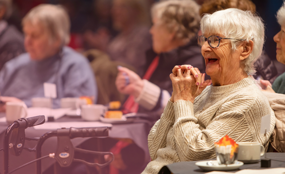 An audience member of the Tea Dance concert smiles with delight.