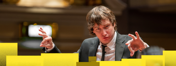 Maxim conducts in a black suit and white shirt.