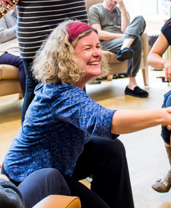 Jane bentley reached and shakes a hand with an older man. The image is cropped on Jane smiling.