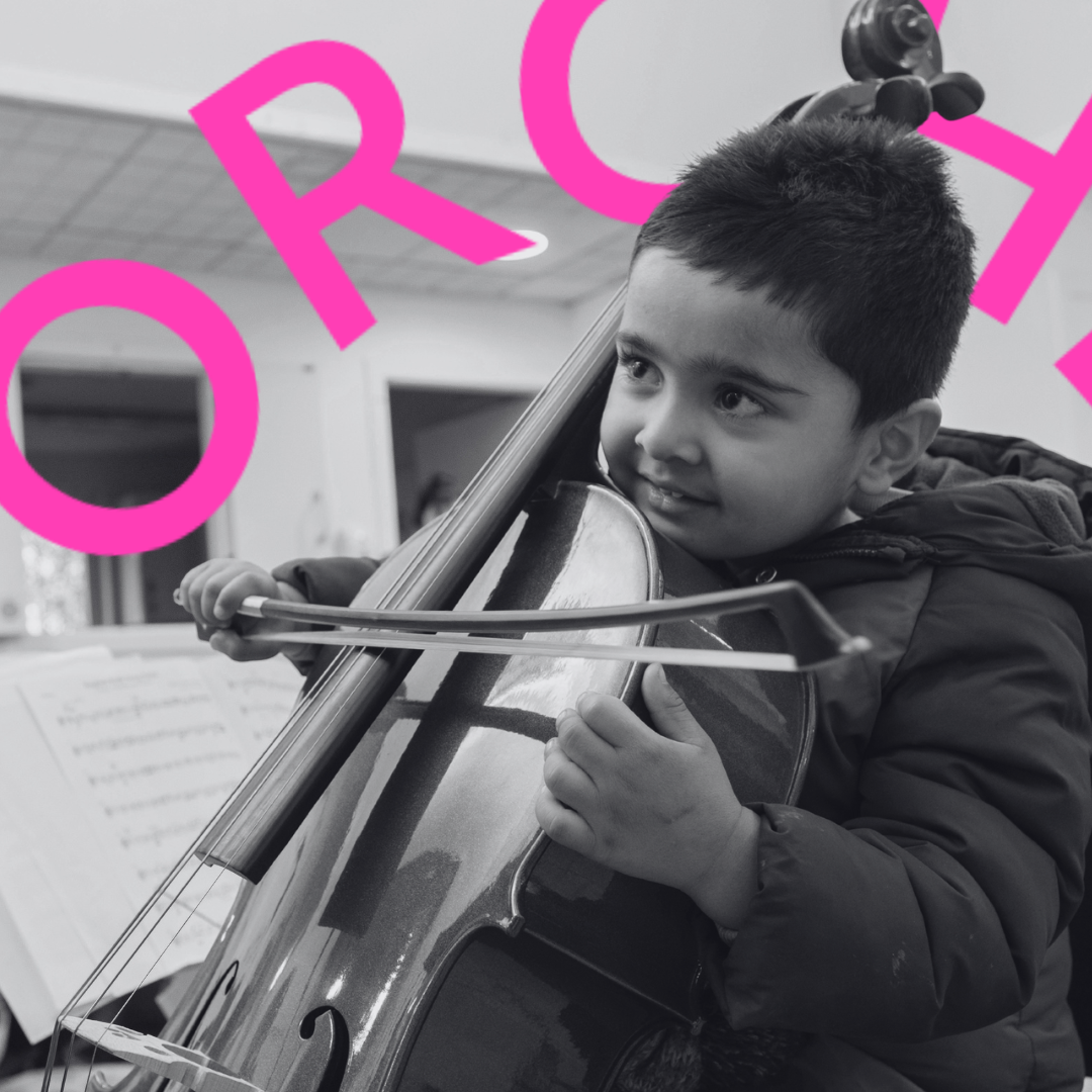 A young boy plays a small cello.