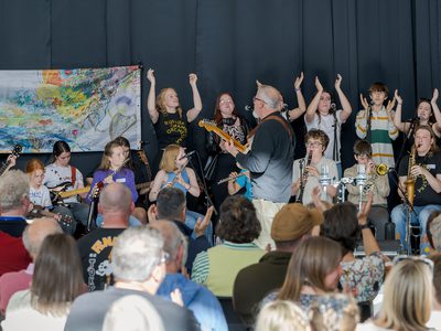 All the participants join and perform on stage with guitarist Paul.