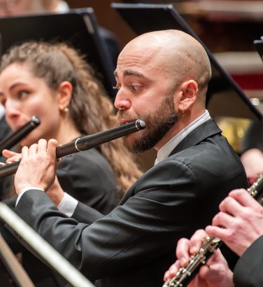 André Cebrián and Marta Gómez play the flute sitting in the SCO desks
