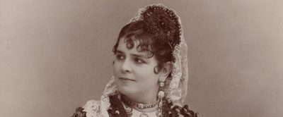 A woman in traditional Spanish dress, her hair in elaborate curls
