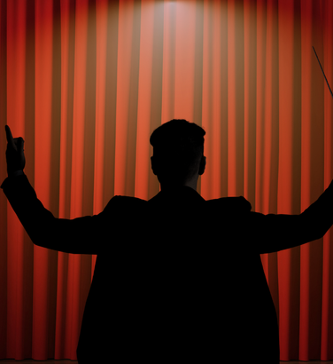 Composer silhouette in front of a movie theatre curtain