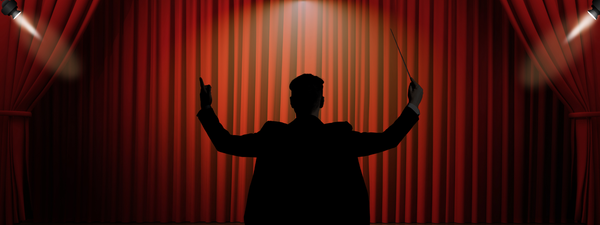 Composer silhouette in front of a movie theatre curtain
