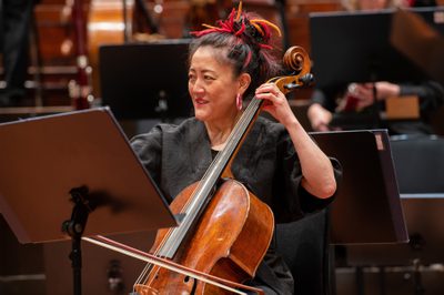 A woman plays the cello, looking to her right